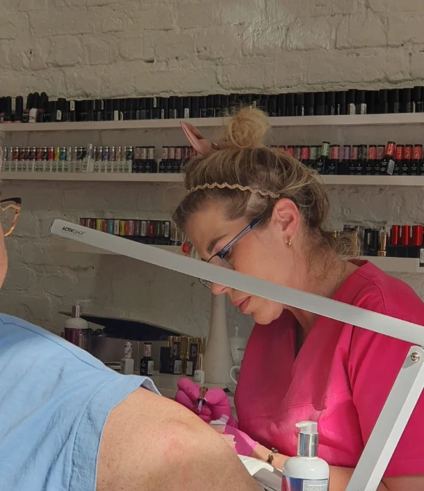Manicure w studiu przy ceglanej ścianie z lakierami